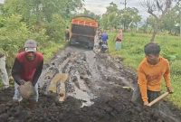 Masyarakat secara swadaya menutup kubangan lumpur di jalan
