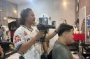 David saat melayani pelanggannya di barbershop Jagal Rambut
