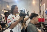 David saat melayani pelanggannya di barbershop Jagal Rambut