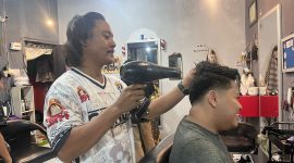 David saat melayani pelanggannya di barbershop Jagal Rambut