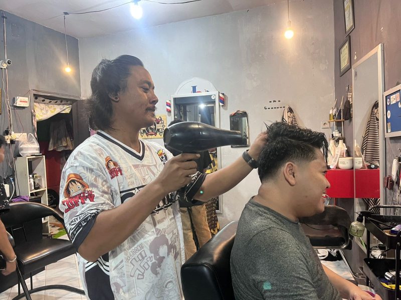 David saat melayani pelanggannya di barbershop Jagal Rambut