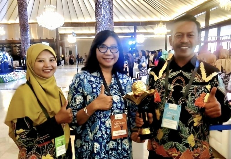 Kepala Dinas Lingkungan Hidup (DLH) Kota Probolinggo, Retno Wandansari (tengah) saat memegang piala penghargaan.