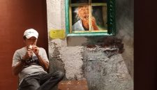 Bambang di samping salah satu karya seni yang dipamerkan