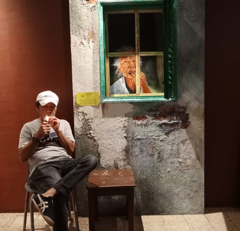 Bambang di samping salah satu karya seni yang dipamerkan